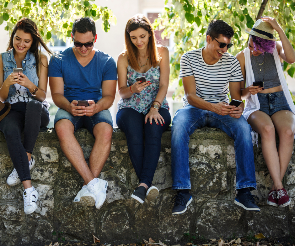 Gruppo di ragazzi che guarda il cellulare e utilizza i social media